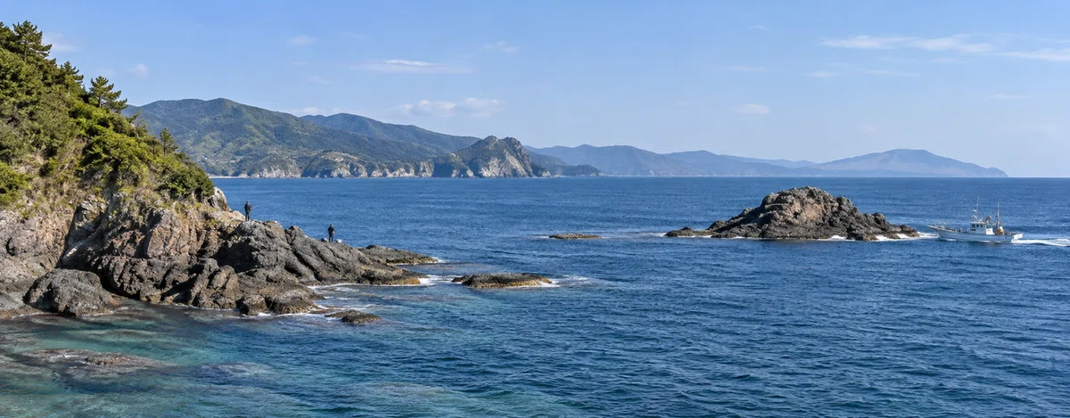 陸続きの地磯と船で向かう沖磯を比べられる海岸の風景