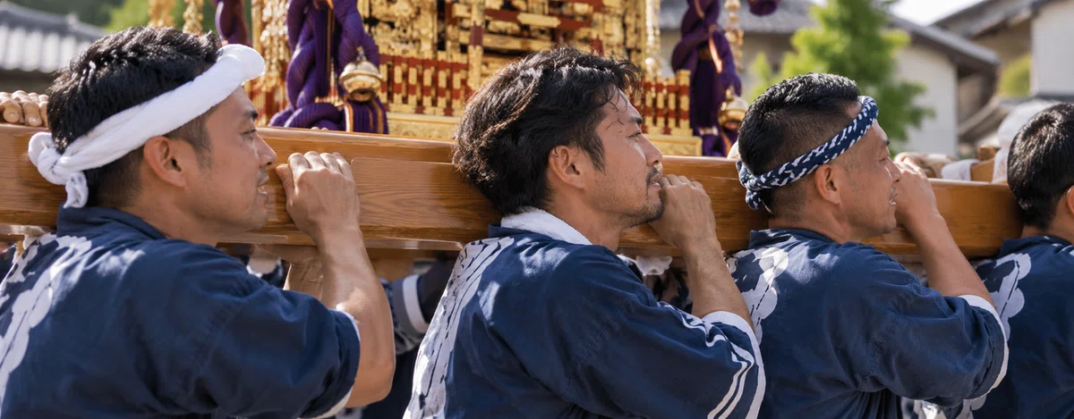 担ぎ手が肩の高さと歩幅をそろえて神輿を支える様子