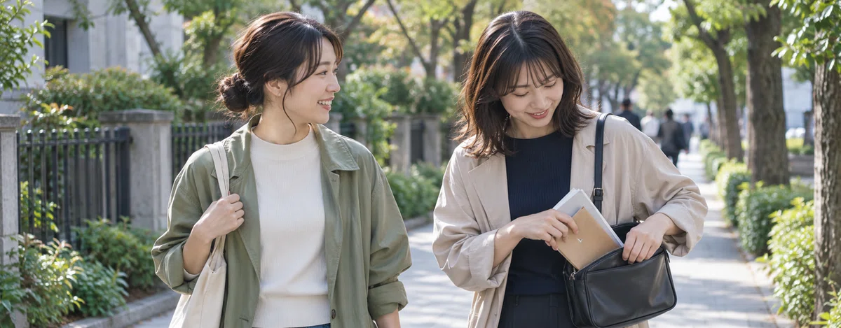 帰り道で冊子と封筒をバッグにしまい、答えを見せずに話す2人