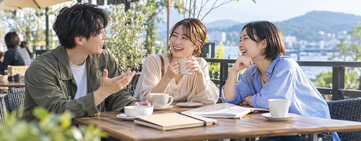 謎解きのあと屋外のカフェで感想を語り合う3人