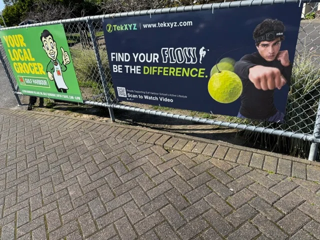 TekXYZ boxing reflex ball promotional banners displayed on a fence outside the school.
