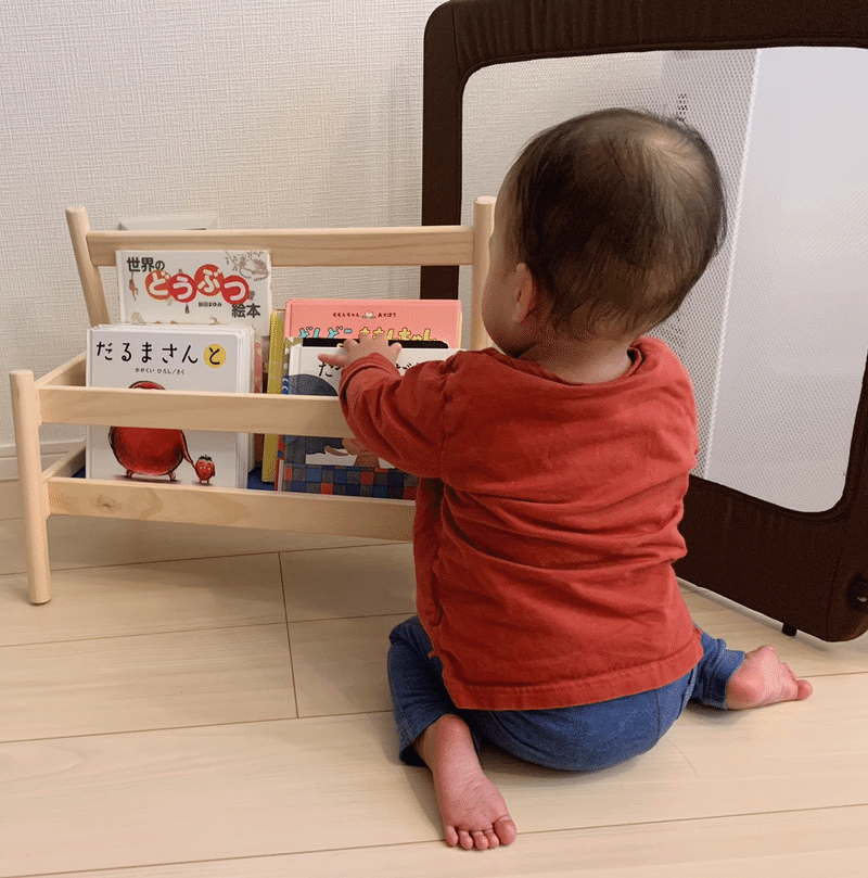 本棚から本を出す赤ちゃんの画像