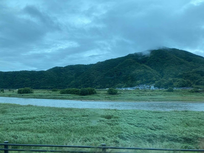 暗い雨雲に覆われた山と川