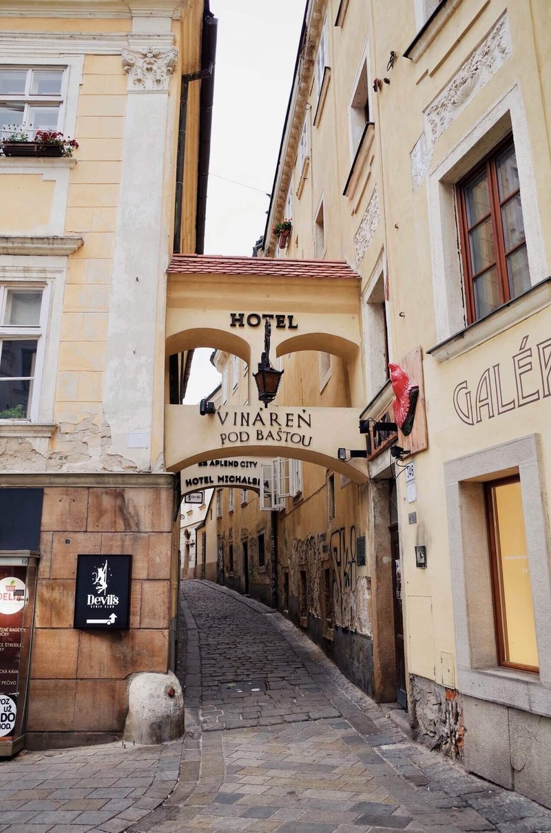 スロバキアの首都・ブラチスラヴァの街並み。クリーム色の壁の建物と、奥まで続く石畳の道