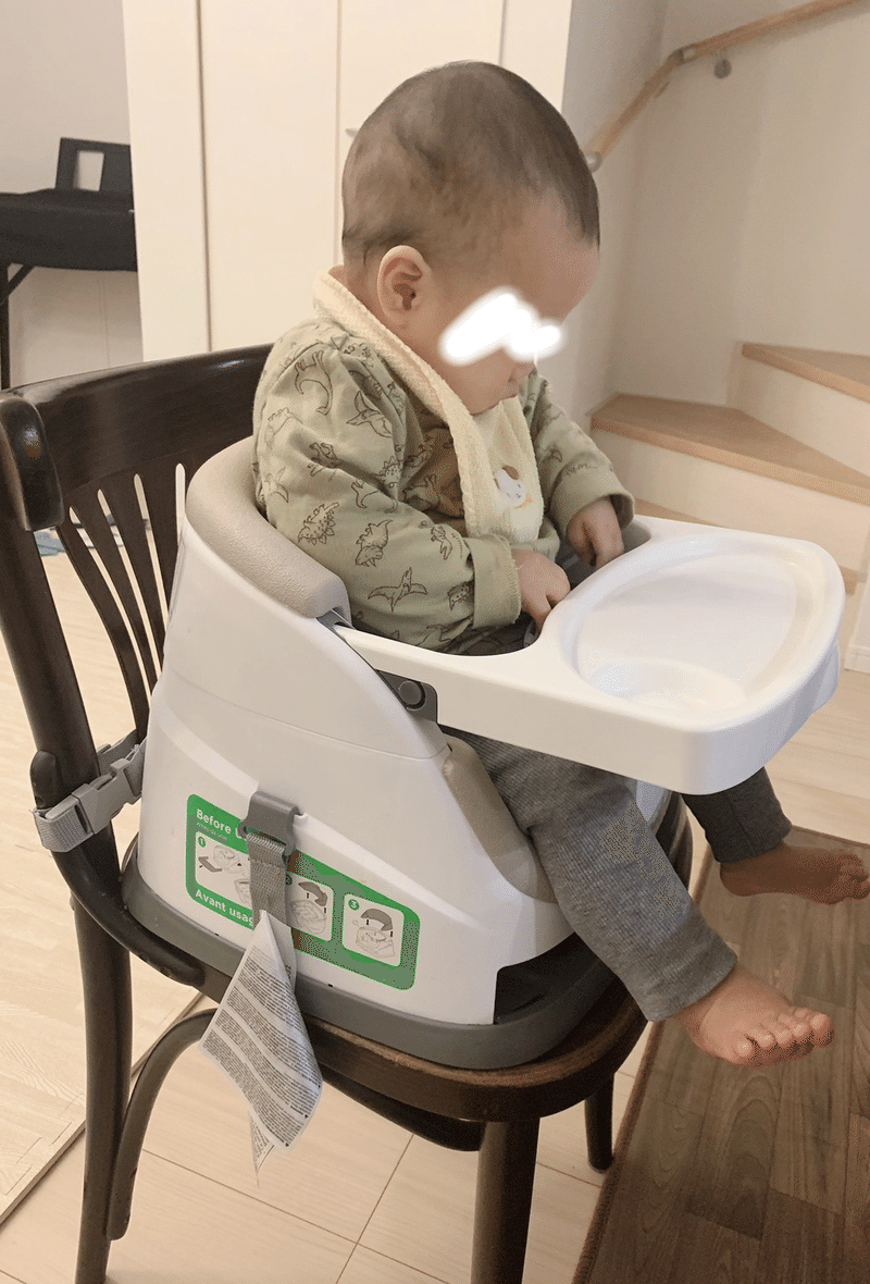 椅子に座ってベルトを触る赤ちゃんの画像