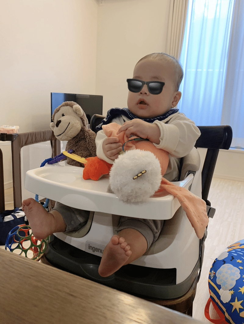 ぬいぐるみと椅子に座る赤ちゃんの画像