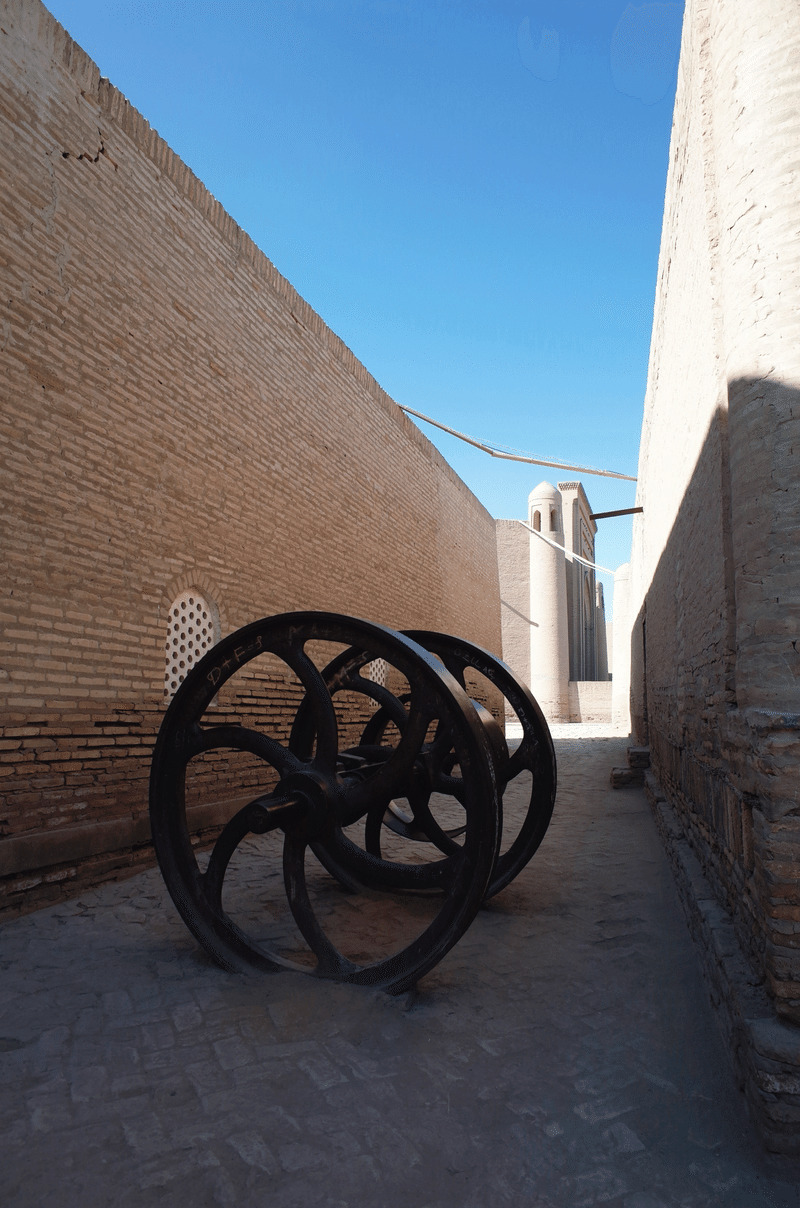 建物に挟まれた狭い道に、大きな車輪が置かれている