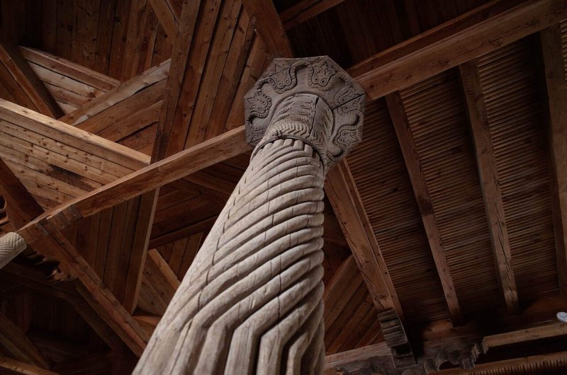 木製の柱を見上げている様子。柱は乾燥しており、古そうに見える