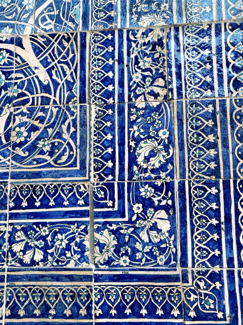 アラベスク模様のタイルのアップ。青色と水色で模様が描かれており、その中に小さく数字が書かれている