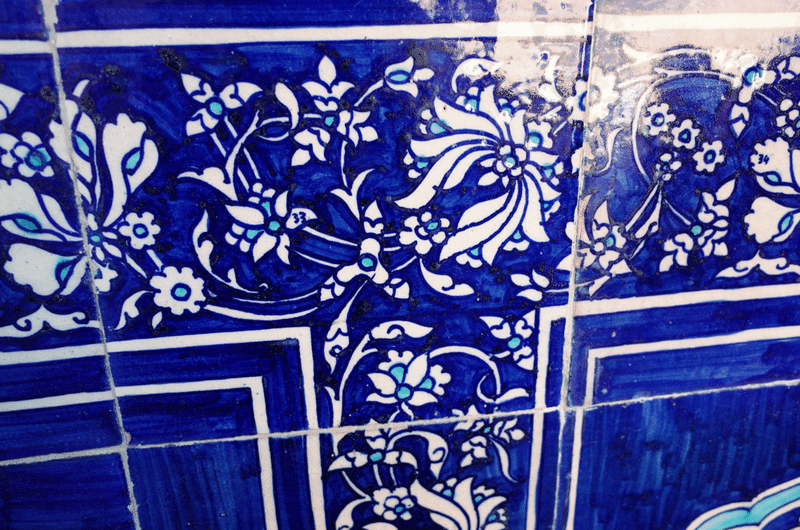 アラベスク模様のタイルのアップ。青色と水色で模様が描かれており、その中に小さく数字が書かれている