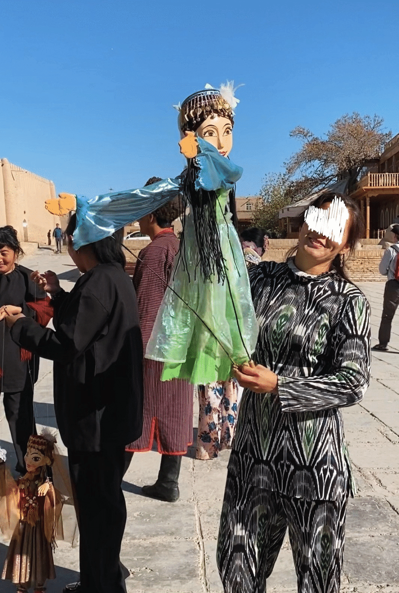ウズベキスタンの踊り子を模した人形を操り、踊らせている様子