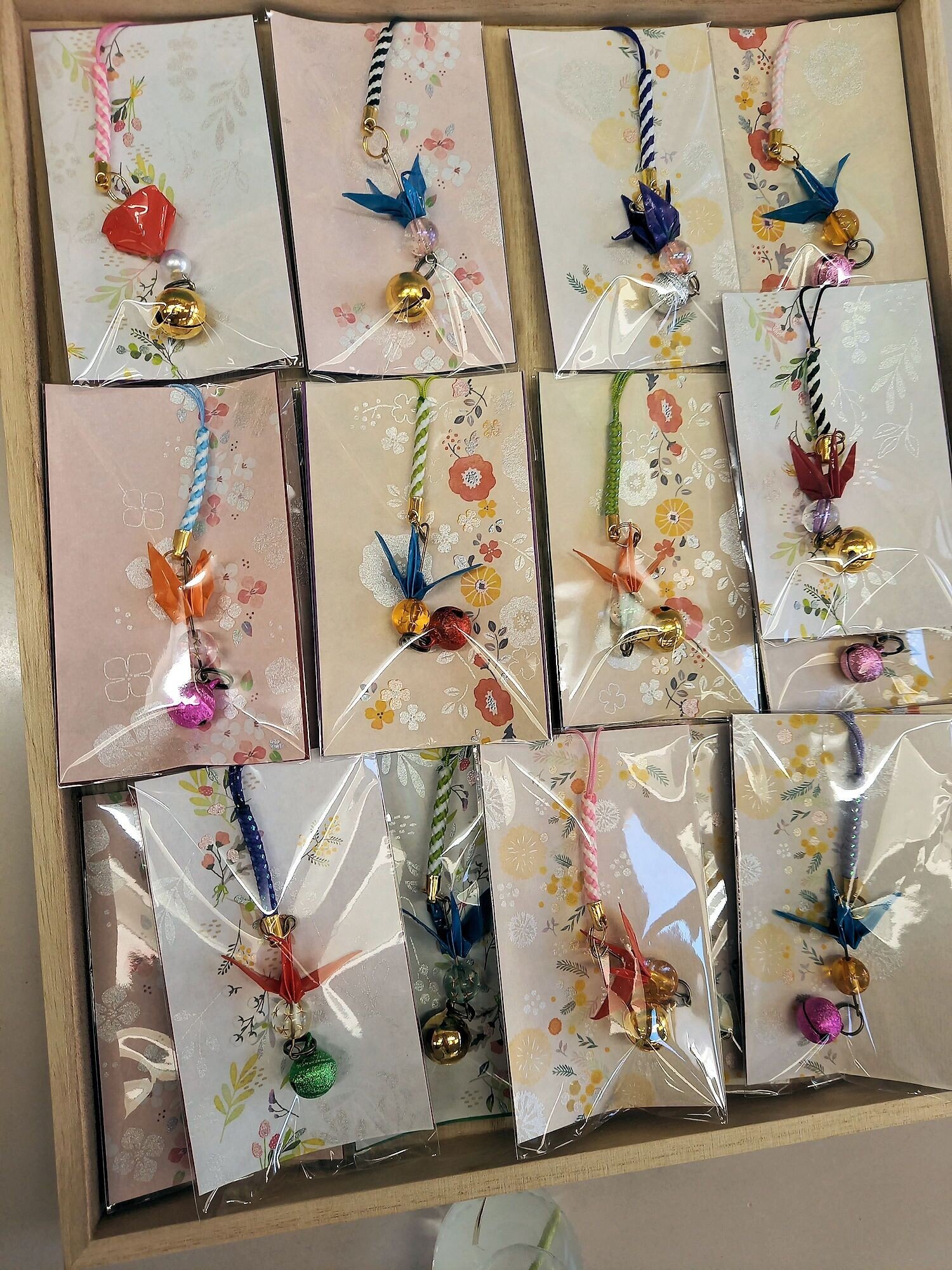 折り紙をレジンで固めたストラップを、綺麗な紙を台紙にして袋詰めにし