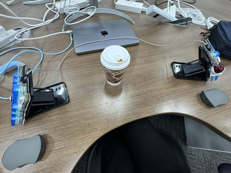 分割キーボードを机に置いて、その間にコーヒーの紙カップを置いている光景