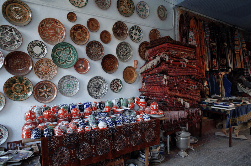 テーブルの上には食器や古そうな絨毯が置かれ、壁にはたくさんのお皿が飾られている