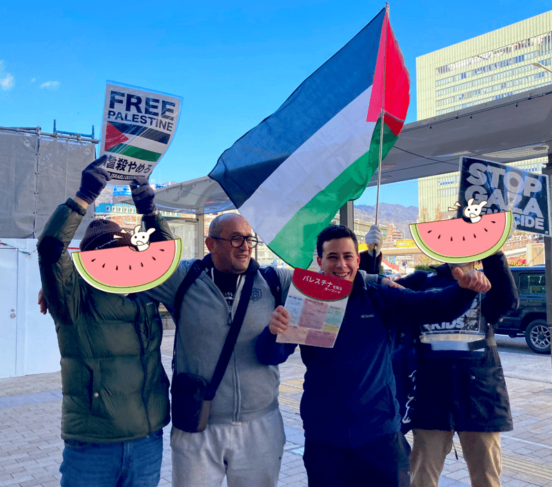 パレスチナ国旗とプラカード、「パレスチナを知るキーワード」を掲げる人々