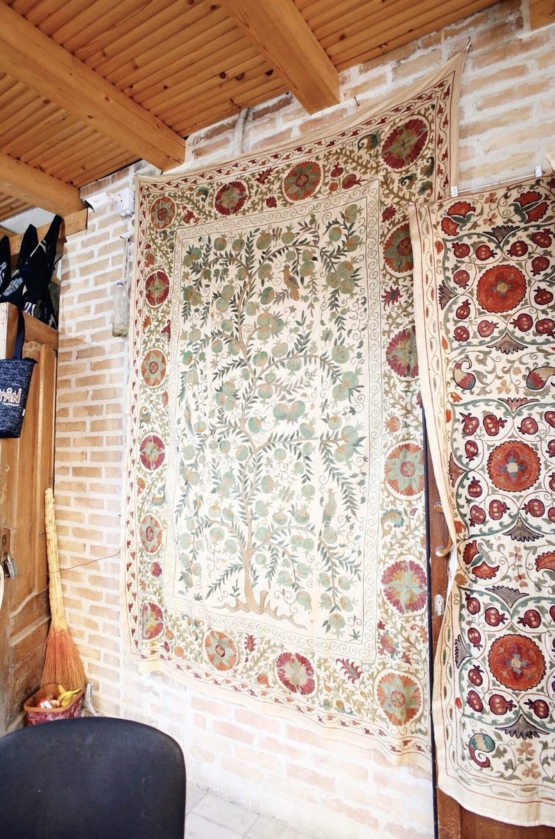 細やかな刺繍が施された大きな布が壁に飾られている様子
