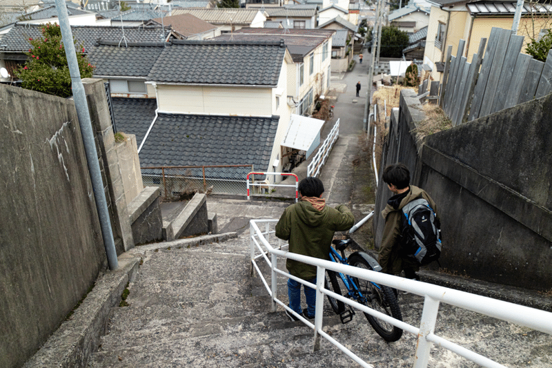 田中町の石階段。自転車を引いて降りていく男の子たち。
