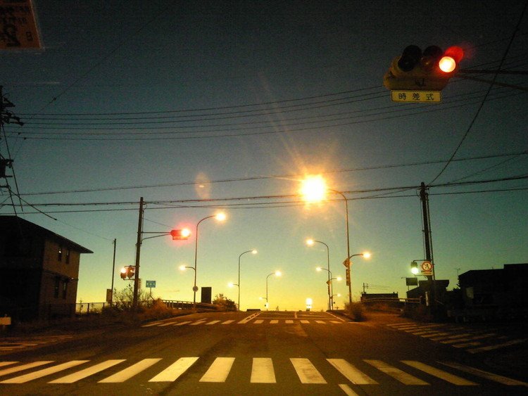 夜明け前の交差点。信号は赤