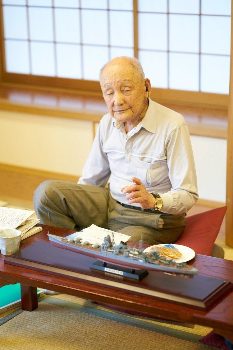常連タマちゃんの友人が作成した軍艦利根のプラモデルを前に話をする田中三也氏。
