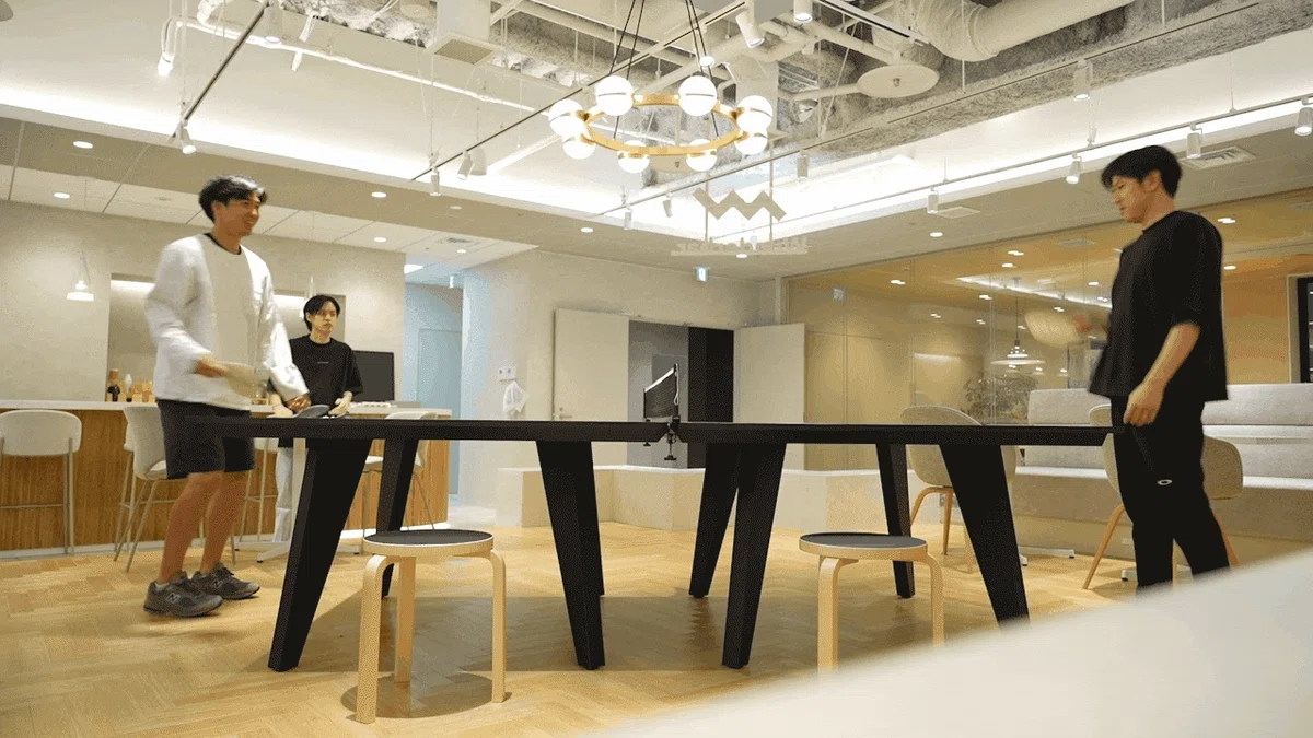 打倒長尾(代表)を掲げて卓球を楽しむメンバーたちのGIF