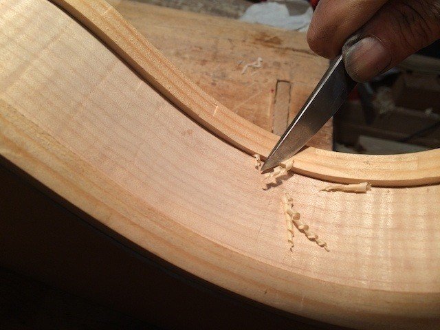 ライニングの不要な部分を削って軽量化します。側板と表板・裏板の接着面積を確保しつつボディを軽量化して木の振動を殺さないための加工です。