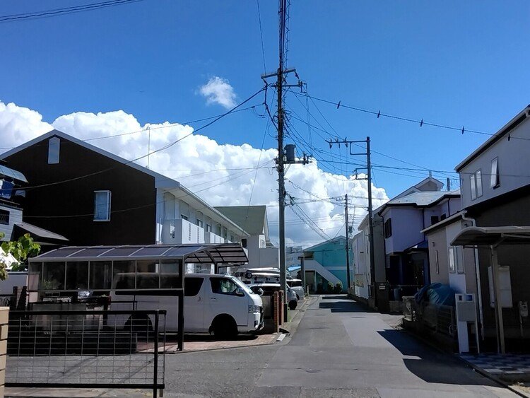 先ほど買い物にウチを出てすぐの眺めです。モクってるな今日も！10日ほど前にも雲の写真上げました。こんな雲の日もあとひと月と続きますまい。