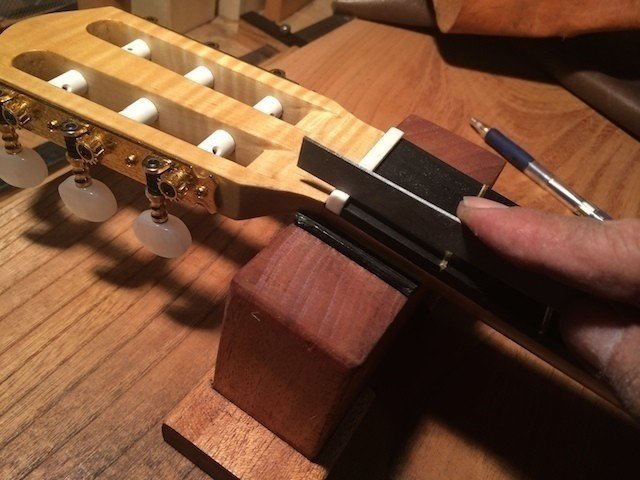 牛骨のナット材を使いました。弦溝を作っているところ。専用のヤスリを使います。弦を張ったときに弦の高さが１フレットよりほんの少し高くなるくらいに溝を切ります。