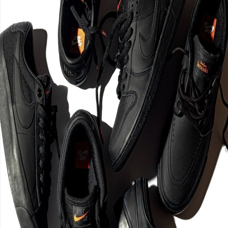 オレンジの夕日に照らされるオールブラックのNIKE SBシューズ