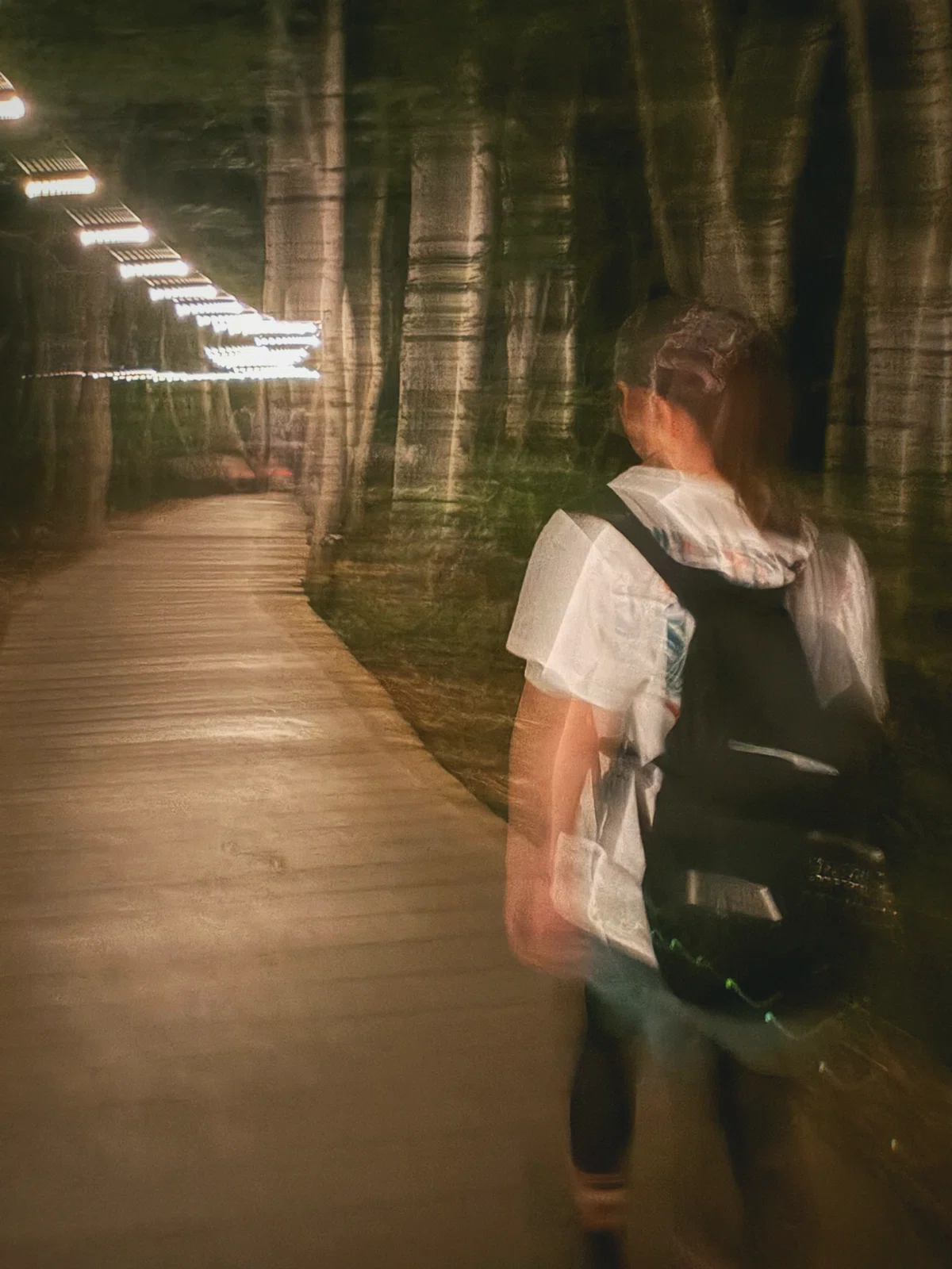 夜のボードウォークを歩く写真