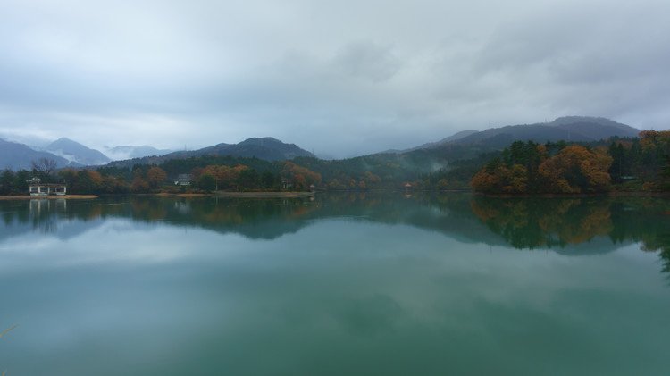 富山県南砺市城端地区にある桜ヶ池公園のため池を撮影しました。 日本ではmacの壁紙に選ばれた「青い池」がとても有名ですが、我が故郷南砺市にも綺麗な池があるので、今回世界に発信したく朝方撮影しました。曇り空で霧雨が降る中での撮影でしたが、イメージ通りの写真が撮れました。晴れていれば地元では有名な袴腰山も見えるのですが、曇り空と朝霧が良い雰囲気を出していると思います。見たままの色で撮りたくて撮影する際はその点に注意して撮影しました。現像もほぼ無修正です。