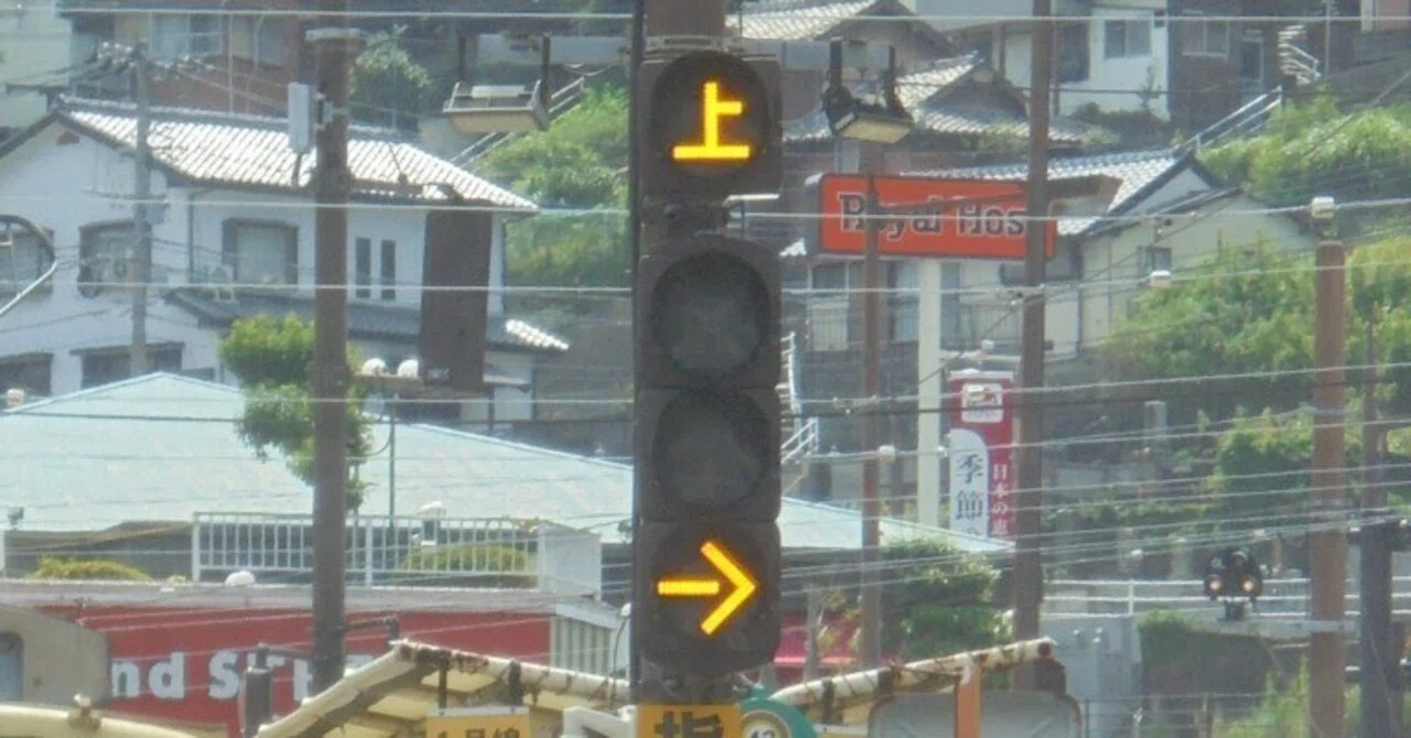 長崎県長崎市蛍茶屋電停付近の「上」信号機と「注意 CAUTION」標識