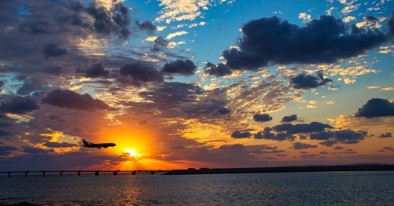 今日の1枚｜瀬長島の夕日 ― 飛行機が光へ向かうとき｜フォト丸