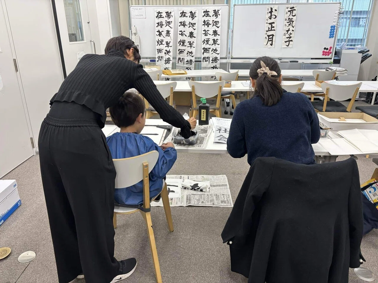 少人数の教室で大人に見守られながら学ぶ子ども