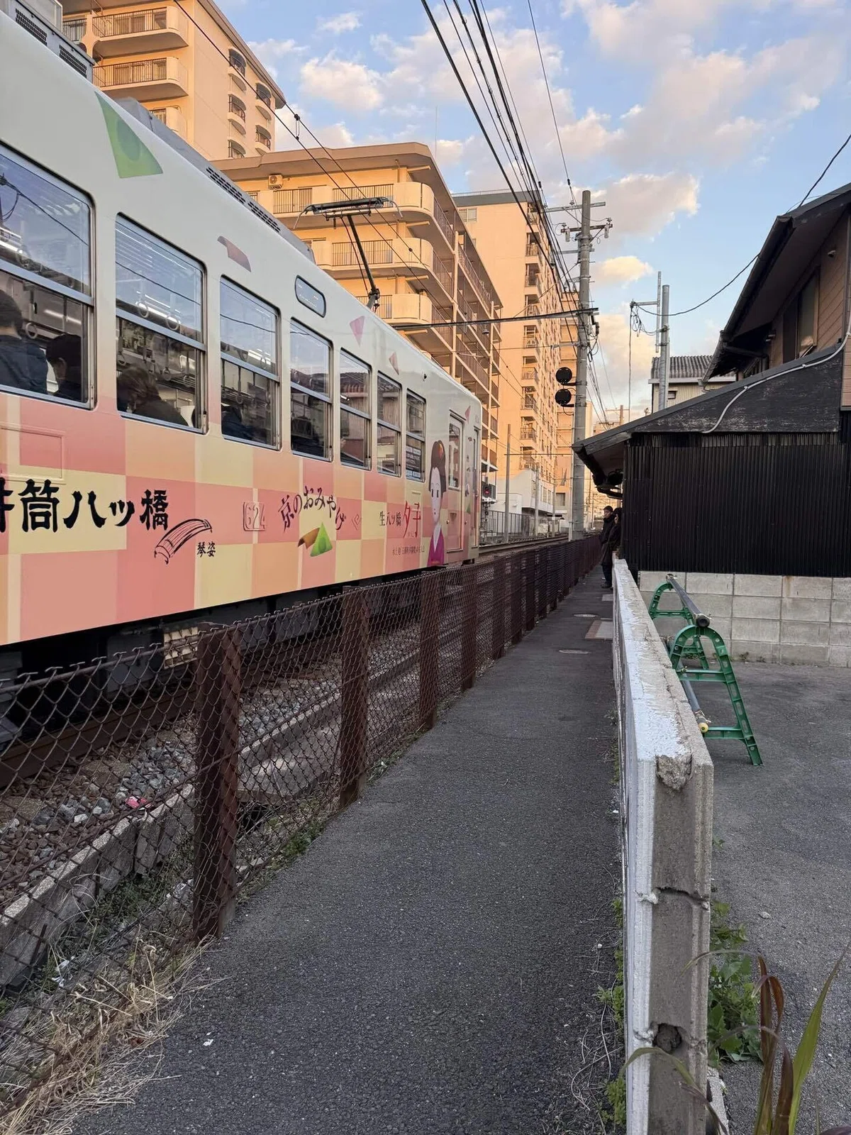 店前の小道とその前を走る列車
