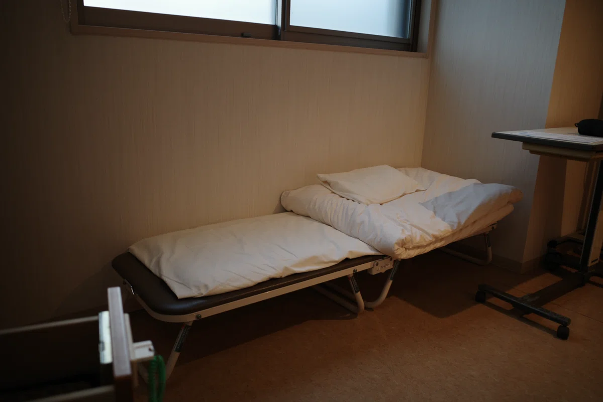 簡易ベッドが置かれた小さな一時滞在用の部屋