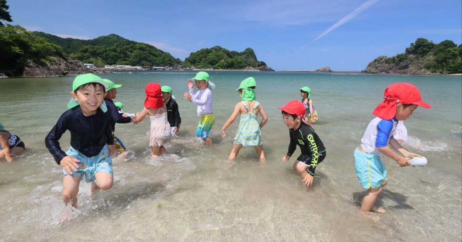 青空と透明な海に上機嫌／新温泉町諸寄で海開き／園児たち浜辺で水遊び