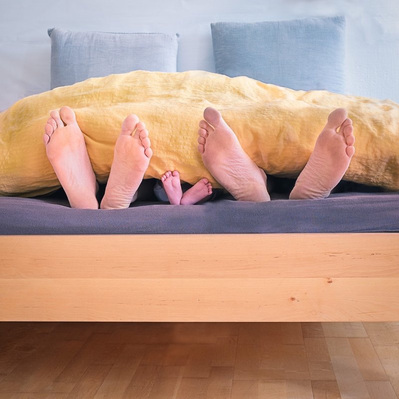 Canva - Family of Three Lying on Bed Showing Feet While Covered With Yellow Blanket - コピー
