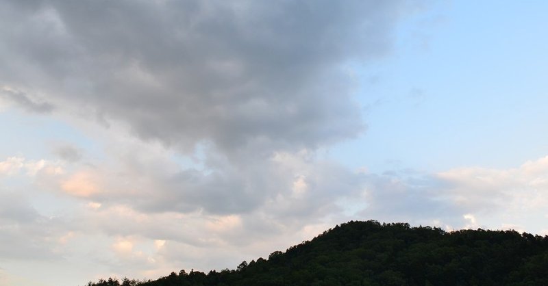 夕立の後の夕暮れの空と山里の畑の風景