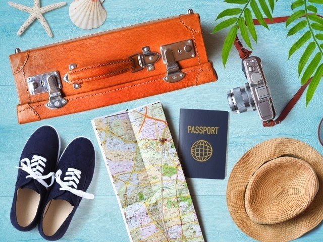 旅にまつわるもの。パスポートや地図、スーツケース、靴、麦わら帽子、カメラ。