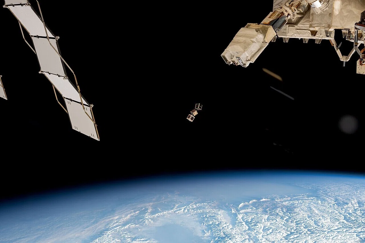 宇宙局の構造物近くで小型衛星が軌道へ放出される様子。軌道上で機体を操作することの難しさが、救済ミッションの失敗を考える手がかりになる。
