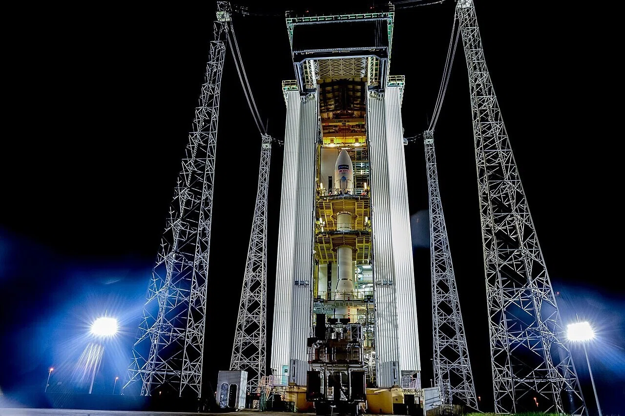 打ち上げタワー内に垂直に組み上げられたロケットの夜の姿。発射前の整備段階の様子がうかがえ、打ち上げ成功が意味する到達点の話へとつながる。