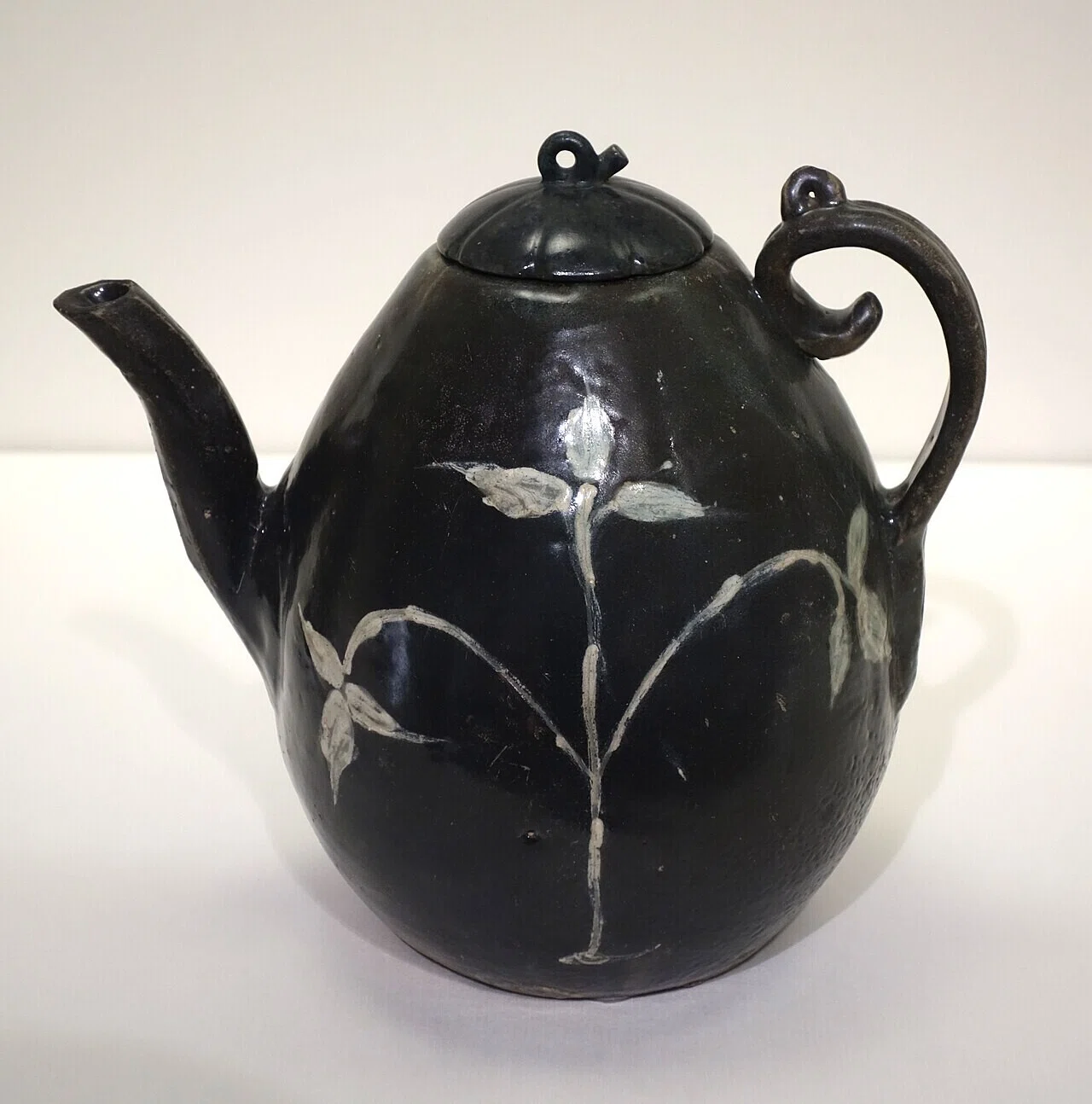 鉄絵で植物文を描いた高麗時代の注器。釉薬の下で鉄がどう発色したかは、素材との交渉を考える入り口になる。