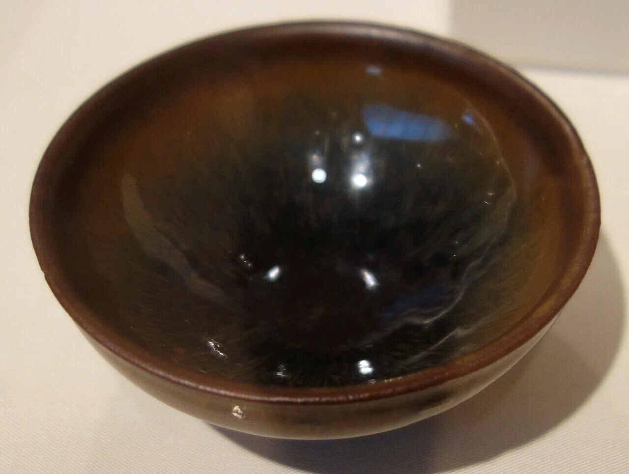 黒褐色の釉に鉄の発色が現れた宋時代の茶碗。鉄が生む落ち着いた色調が画面の厚みを考えるヒントになる。