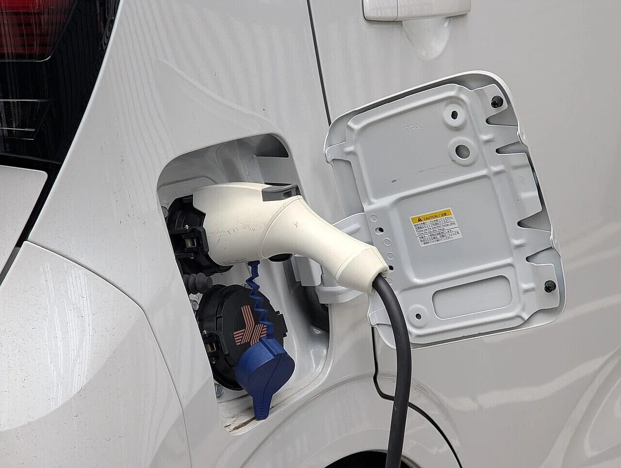電気自動車の充電ポートに充電ケーブルが接続されたところ。新興ブランド同士の競争が先鋭化するなか、充電対応も比較の軸になりつつある。