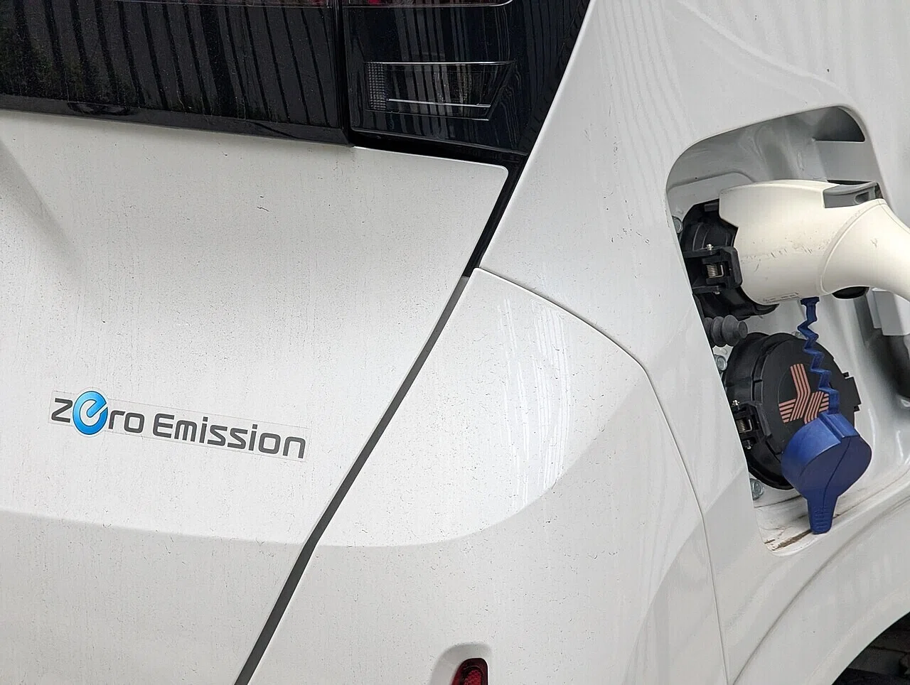 電気自動車の充電ポートにプラグが差し込まれた様子。「zero emission」の表示が、環境規制の厳しい欧州でEVが戦略の核となる理由を物語る。