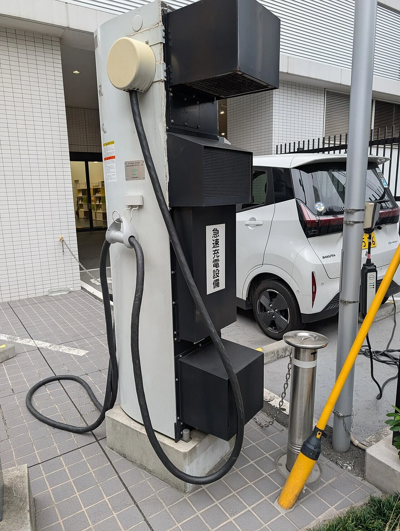 駐車中の白い電気自動車の脇に設置された充電ステーション。購入判断を左右する充電インフラの整備が、中国メーカーの欧州展開の鍵を握る。