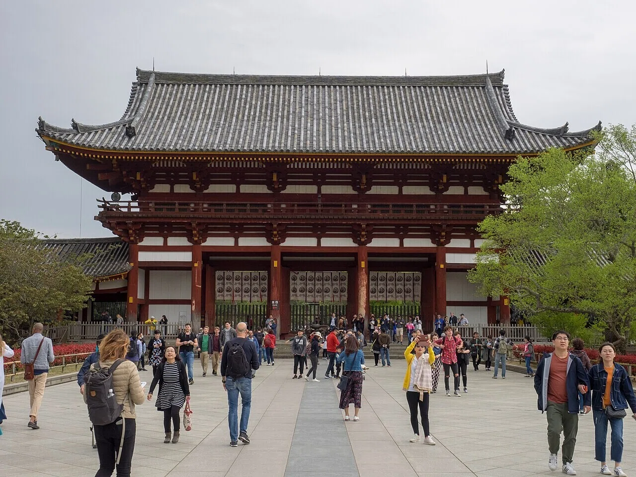東大寺の大きな木造門前に広がる石畳の広場と、行き交う観光客の姿。晴れた日の人出の多さが、過ごしやすい天気を物語る。