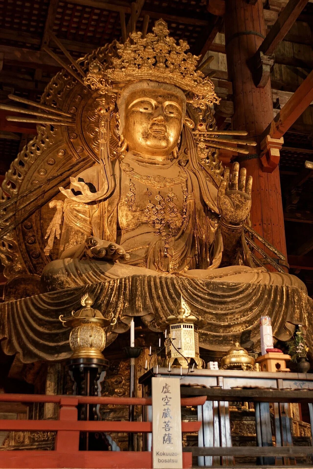 東大寺金堂に安置された金色の仏像、虚空蔵菩薩像。装飾的な光背が堂内の静けさの中で際立ち、奈良の文化の厚みを物語る。
