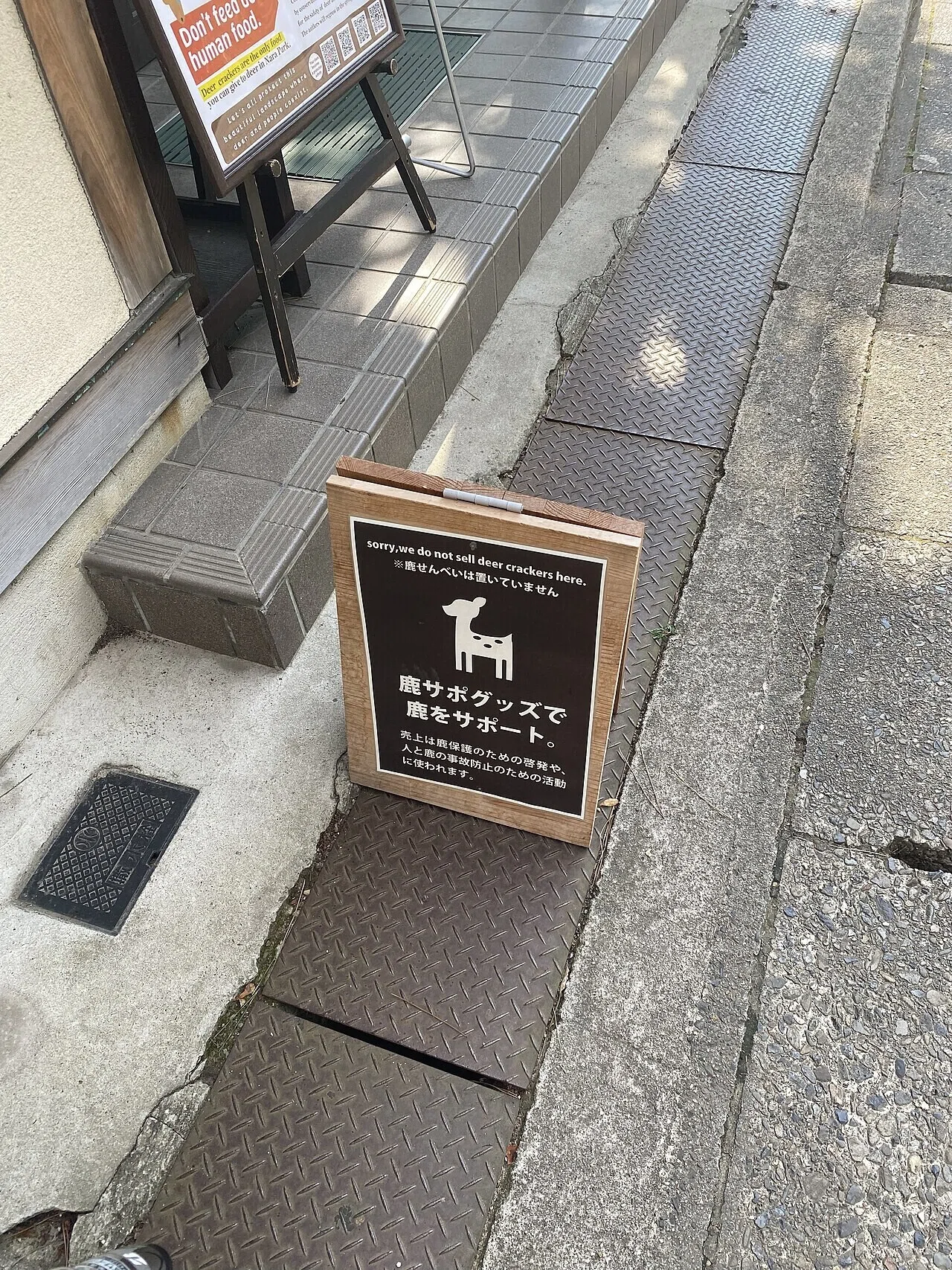 「鹿せんべいは売っていません」と書かれた木製の看板が店先に立つ。奈良ならではの風景が見て取れる。