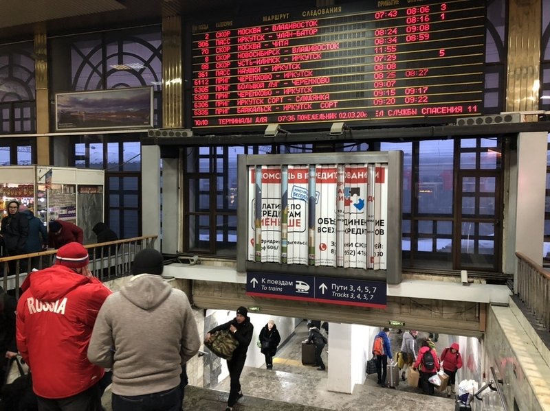 イルクーツク駅の構内の写真。電光掲示板に各方面の電車情報が表示されている